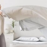 Lady placing bed linen