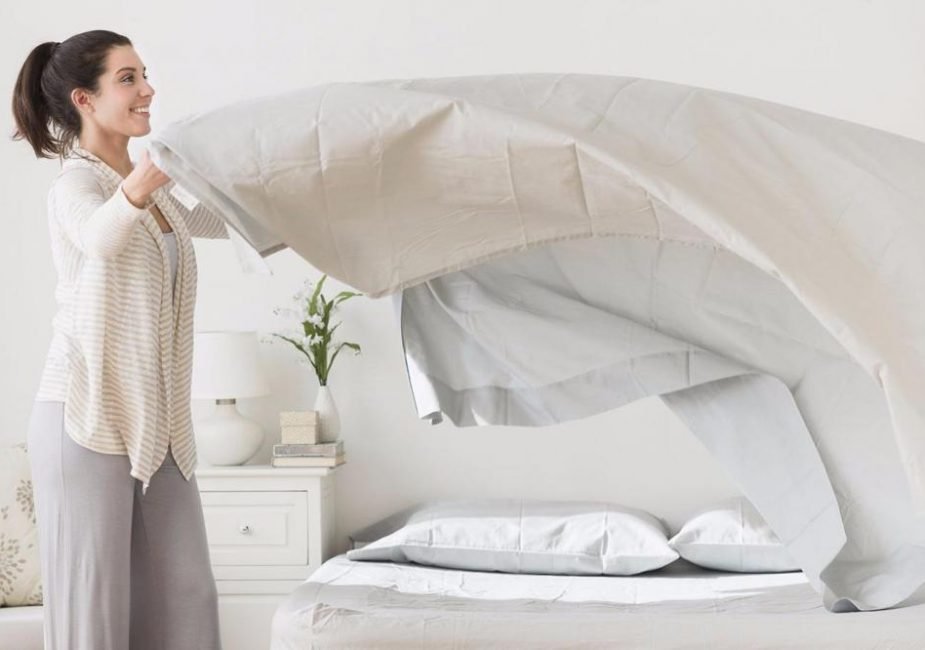 Lady placing bed linen